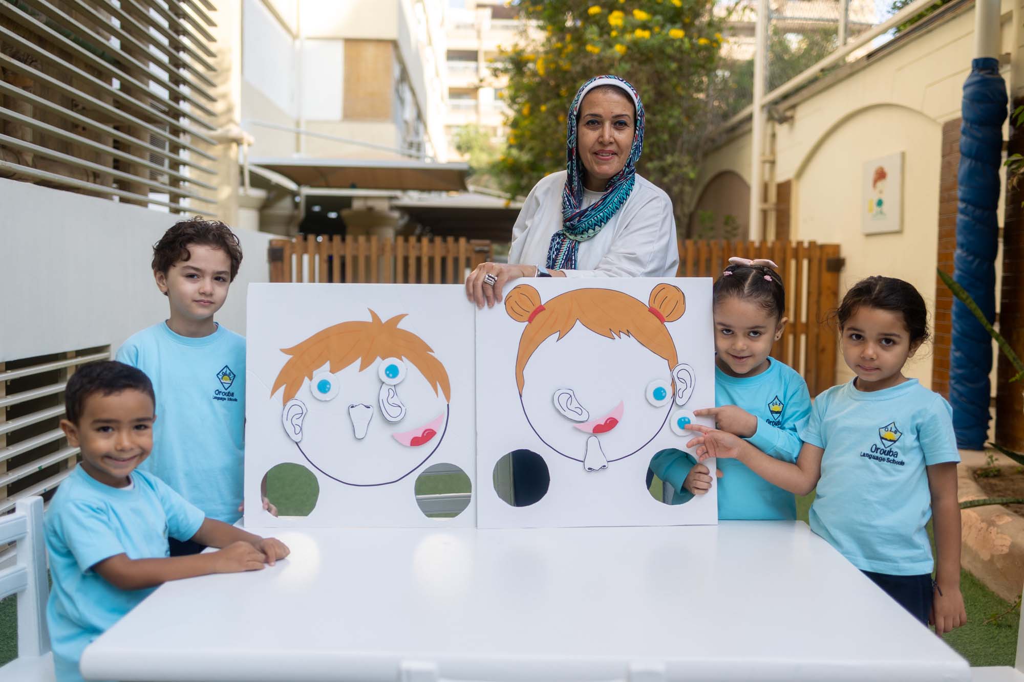 Kindergarten children and their teacher sharing a classroom project