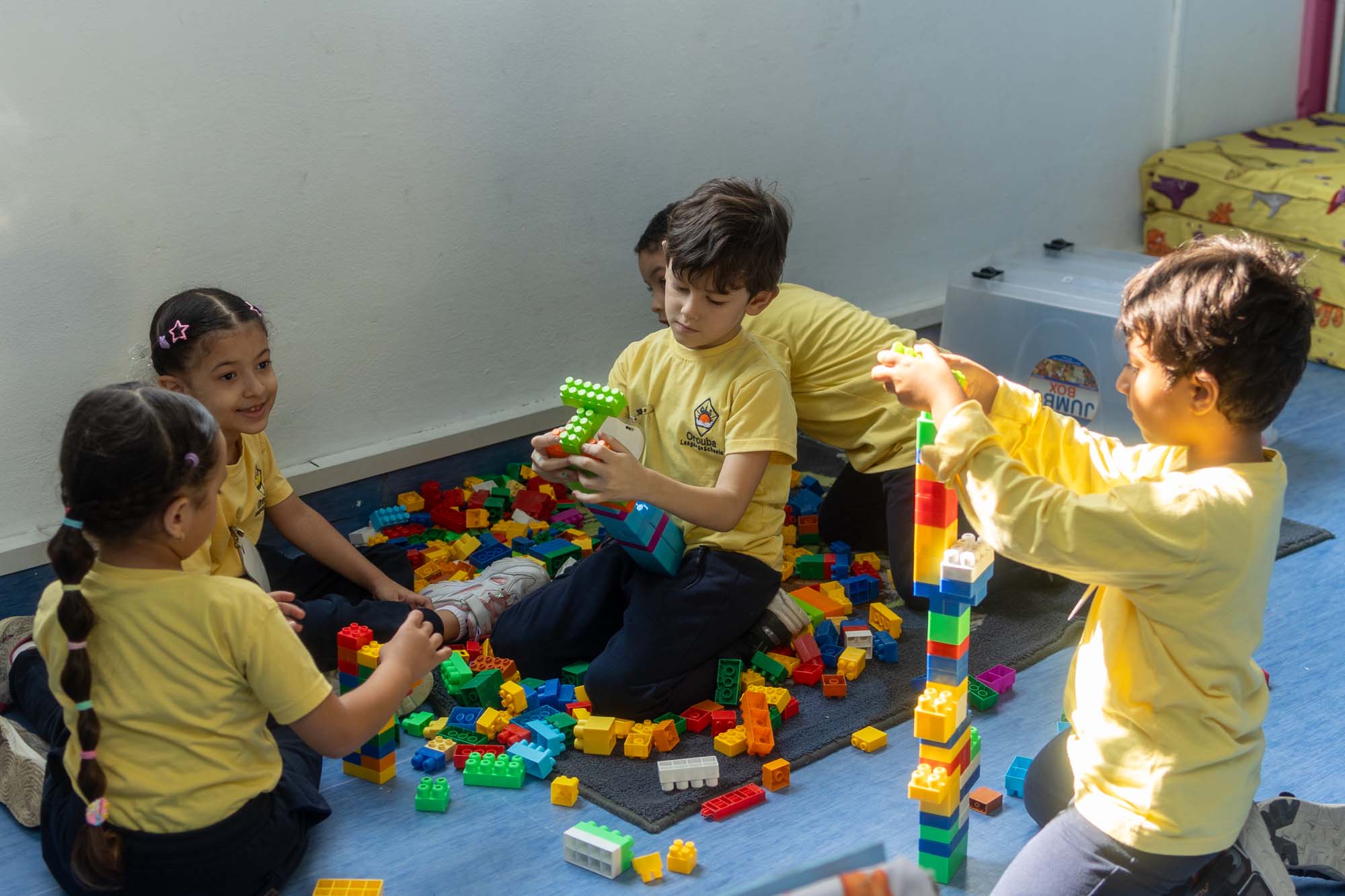 Kindergarten children building with colourful construction toys