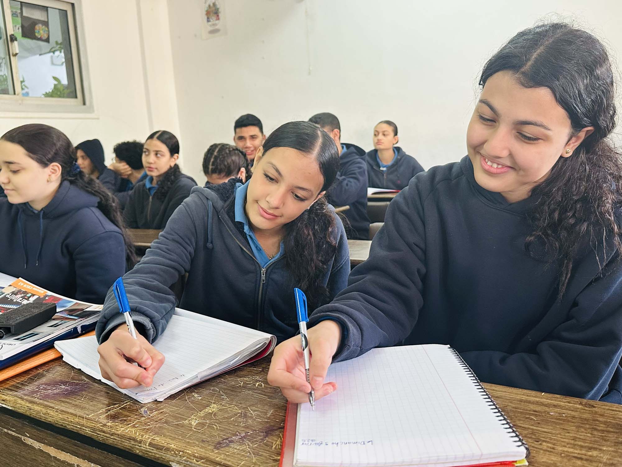 An OLS teacher guiding a preparatory student through written work