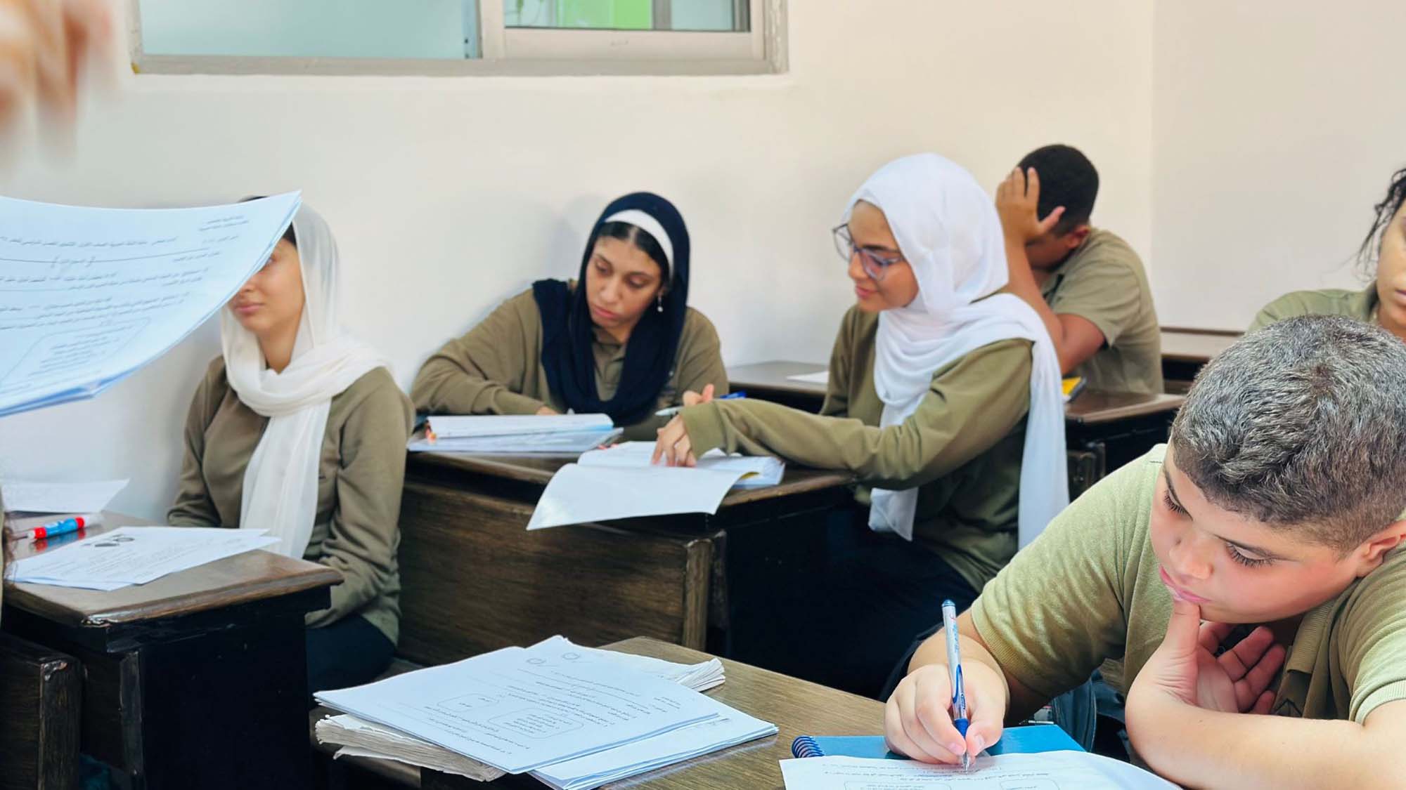 Secondary students studying and discussing classroom work