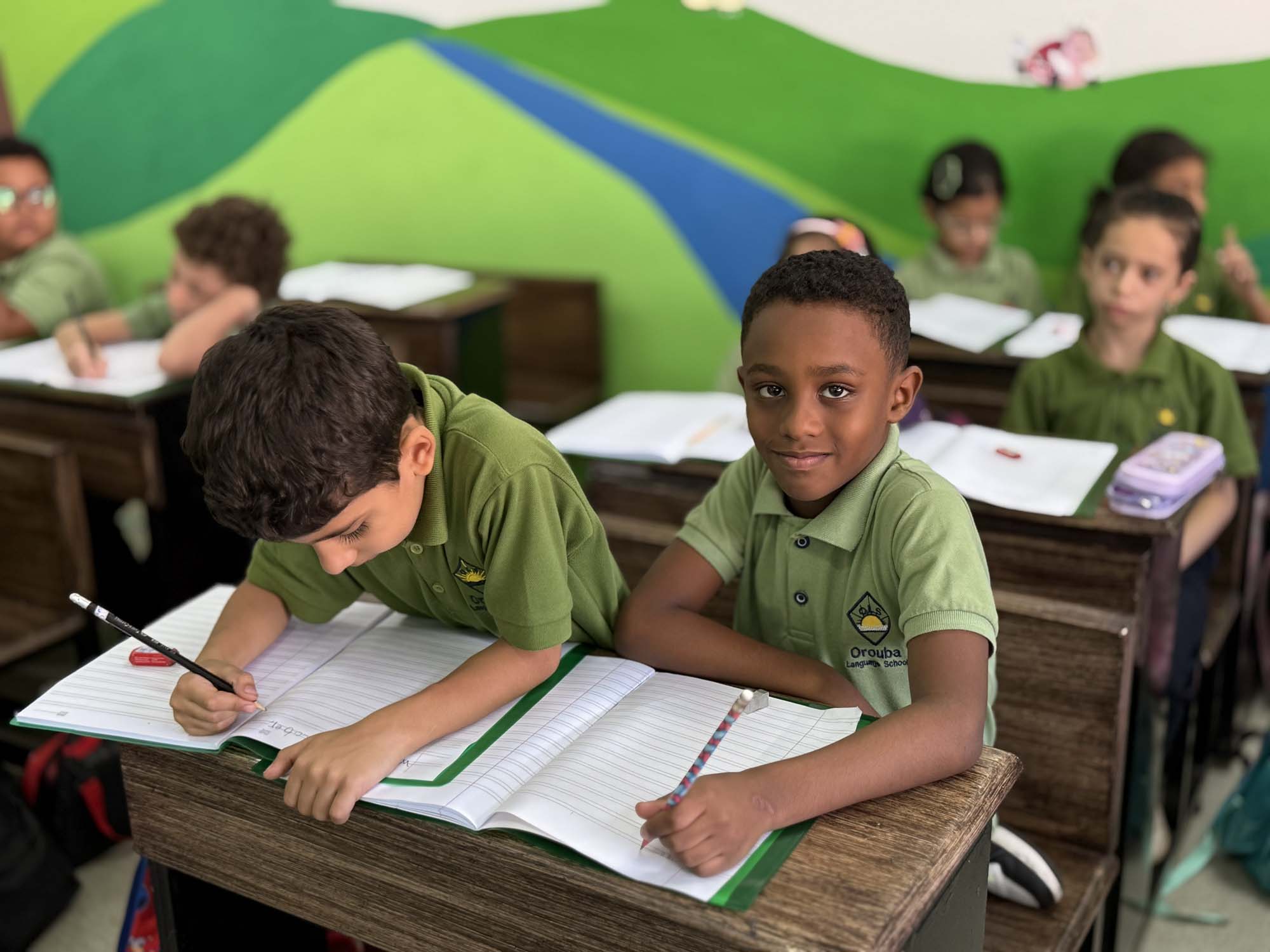 Primary pupils practising writing in their classroom
