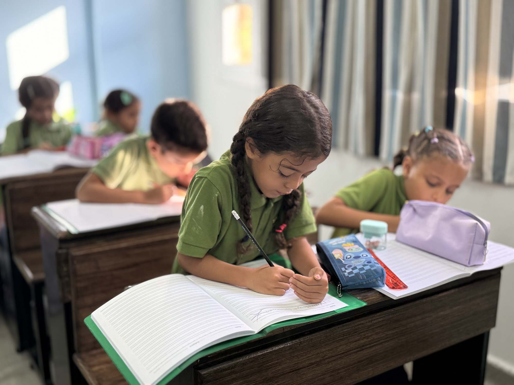 Primary pupils concentrating on writing activities