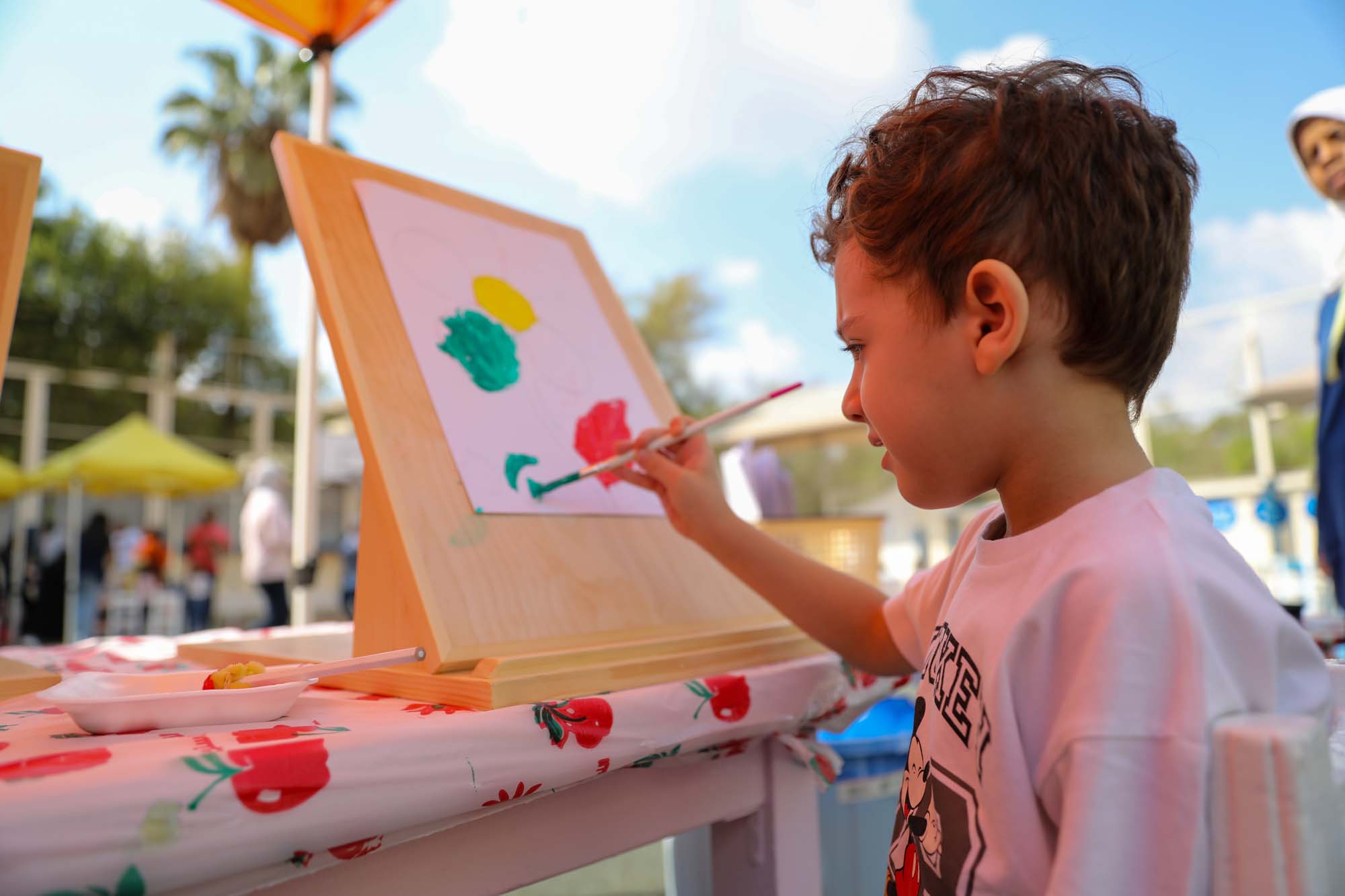 A young OLS pupil painting at an easel during the colour festival