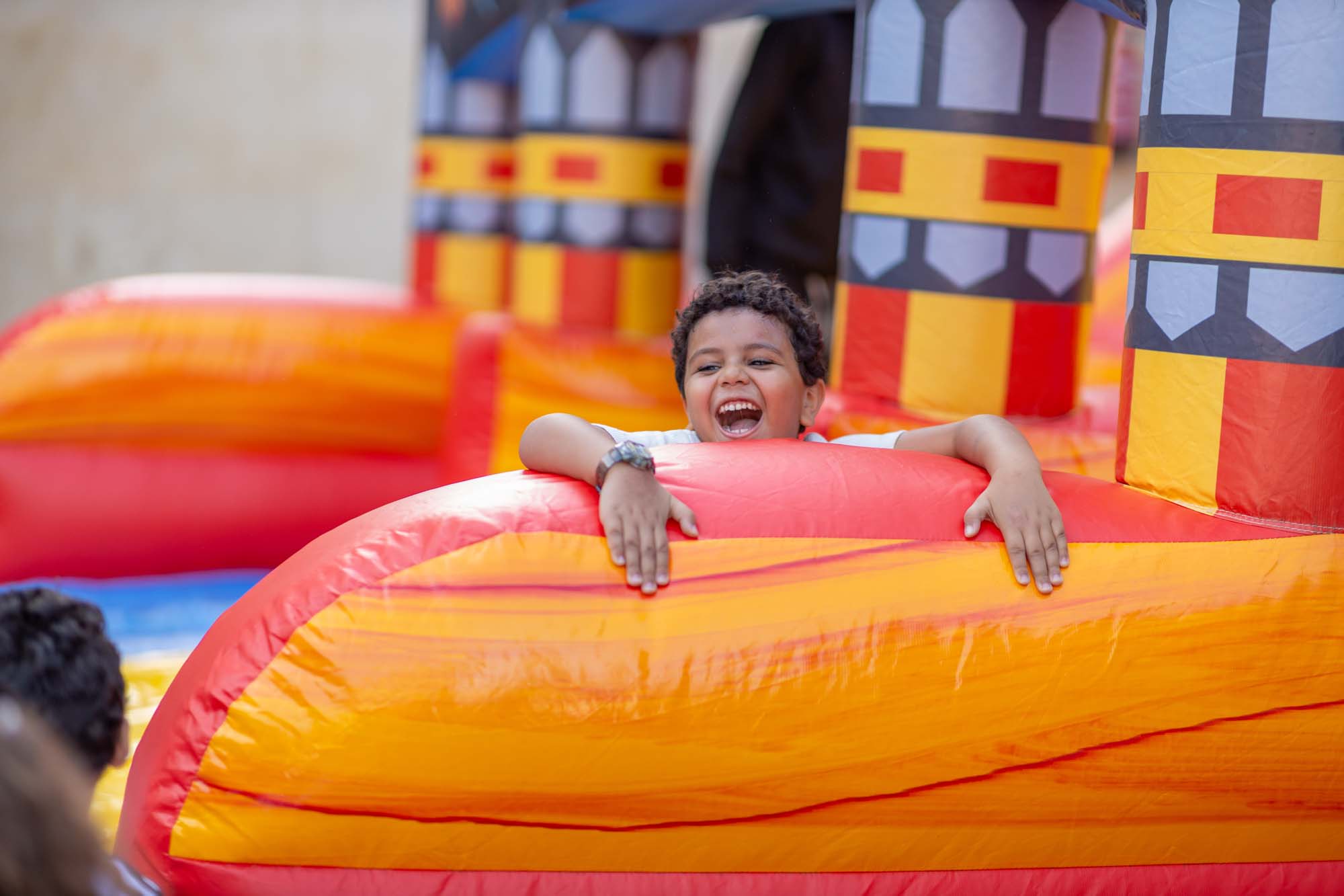 A child enjoying an inflatable play activity at OLS Family Day